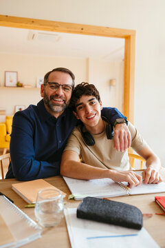 Father and son doing homework at home