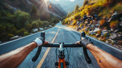 Naklejka premium A man is riding a bike down a road with mountains in the background