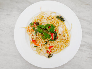 Spicy seafood spaghetti in a white plate