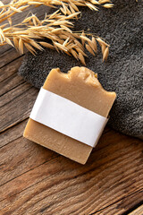 A piece of natural household soap and towel on wooden background. Soap packaging mock up. Natural