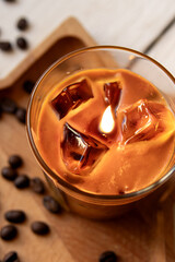 Gel candle in glass cup. A trend candle in the form of iced coffee. Lighted candle closeup