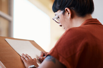 Artist, drawing and learning on paper in studio process of creativity at college with project. Art, student and woman planning sketch with pencil on board in university workshop with talent or skill