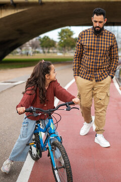 father with his little daughter walking in the park outdoors