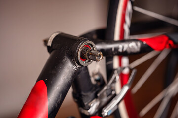 Close-up of a bicycle crank arm without the pedal, highlighting the mechanical details and wear.