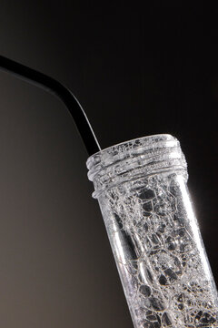 Soapy mixture with a metal straw in a plastic flask