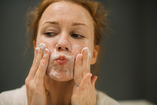 Woman doing soapy facial massage