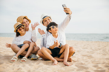 Creating memories at the beach a family shares laughter and joy while taking a playful selfie near...