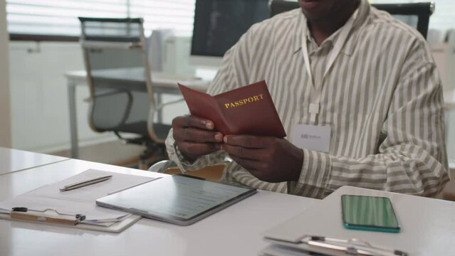Cropped shot of financial manager taking passport from female client when providing loan in bank