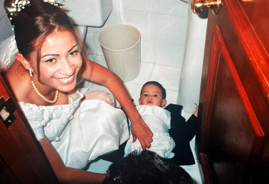 Mother changing her son's diaper at her wedding