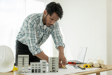 Architects studying floor plans, serious civil engineers working with documents on real estate...
