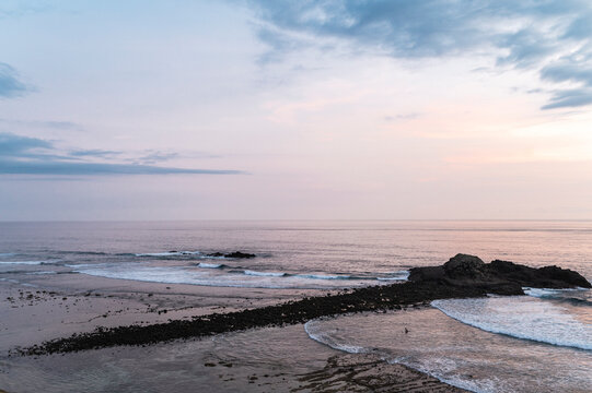 Surfers Wading Through Low Tide at Dusk