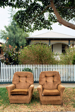 Vintage armchairs discarded on suburban street
