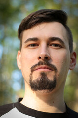 Obraz premium A guy poses outdoors in a park. Summer days, summer mood.