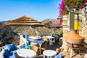 Cafe restaurant with sun umbrellas and beautiful mountain view in Kastro village, Sifnos island, Greece