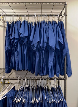 Professional Uniforms on Coat Hangers in closet rack 