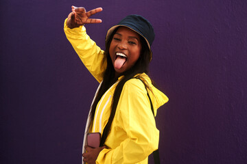 Peace sign, tongue out and portrait of black woman in studio for happiness, confident and fashion....