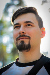 Obraz premium A guy poses outdoors in a park. Summer days, summer mood.