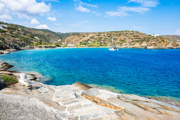Steps to beach and view of azure sea bay near Chrysopigi monastery, Sifnos island, Greece