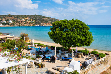 Sun loungers and umbrellas in Platis Gialos village and sea beach view, Sifnos island, Greece