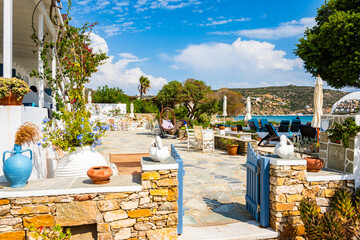 Beautiful architecture of Platis Gialos village with colorful flowers in pots near beach, Sifnos...