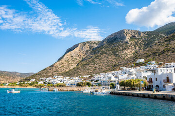 View of Kamares port and village with white houses on hill in mountain landscape, Sifnos island,...