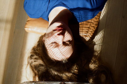 Blurred portrait of young woman enjoys sunrays at home