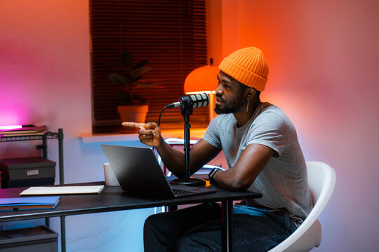 A man speaks into a microphone recording a podcast