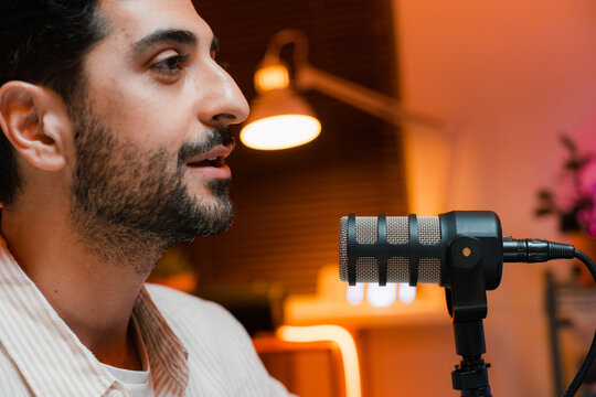 A man speaks into a microphone in the studio