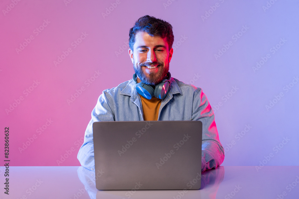 Aufkleber a man is sitting at a table, focused on a laptop computer in front of him. he appears to be engaged 