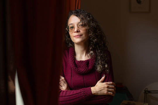 Pensive woman with round glasses looking at camera