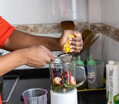 Hand adding ingredient to blender