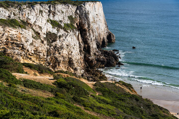 Praia do Beliche beach in Sagres, Algarve, Portugal. Sunny day with surfers in the sea