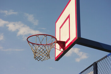 An old basketball hoop against a sky background. Close up.