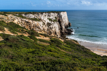 Praia do Beliche beach in Sagres, Algarve, Portugal. Sunny day with surfers in the sea