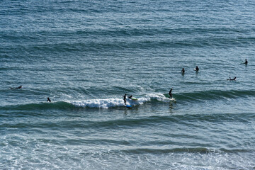 Praia do Beliche beach in Sagres, Algarve, Portugal. Sunny day with surfers in the sea