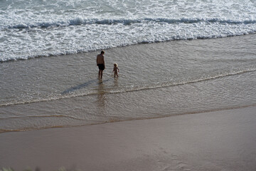 Father and little daughter playing at Praia do Beliche beach in Sagres, Algarve, Portugal. Sunny day at sunset. Family