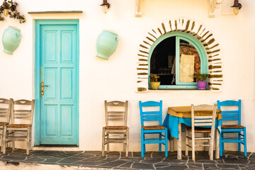 Table with two blue chairs in front of typical Greek taverna restaurant in Apollonia village,...
