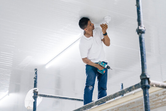 Man installing security camera on ceiling