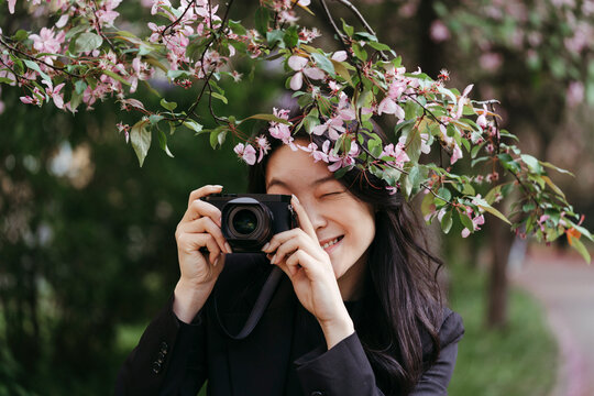 A woman takes pictures of spring nature in the park.