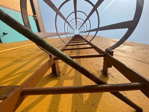 Monkey ladder with yellow concrete wall in an industry