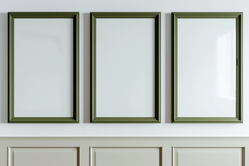 a mock-up showcasing three empty posters in olive green frames on a white wall.
