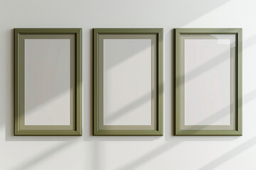 a mock-up showcasing three empty posters in olive green frames on a white wall.