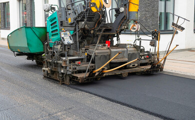 Repair of asphalt road surface - old layer removed and a coating Industrial pavement truck laying new fresh asphalt on construction site. Copenhagen, Denmark - May 4, 2024.