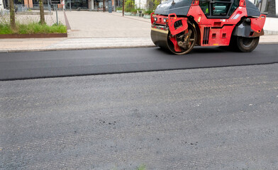 Road construction asphalt roller machine at work. Heavy Vibration roller compactor at pavement works for road repairing.