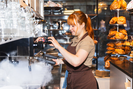 Side view of a barista preparing hot latte