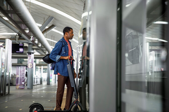 Commuter boarding with electric scooter in train