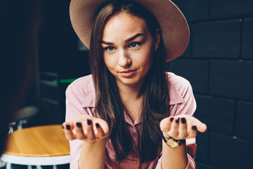 Attractive hipster girl in trendy hat explaining to boyfriend her idea during meeting in...
