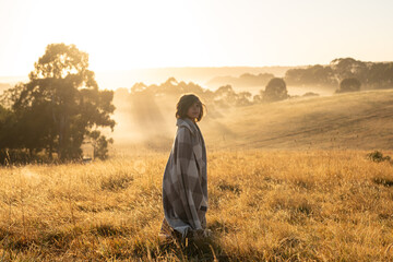 A little boy watching the sunrise in the countryside in Australia