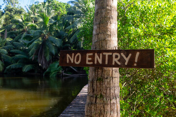 No entry sign on a tree next to a river on Seychelles Island 