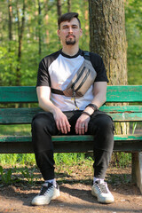 Obraz premium A guy poses outdoors in a park. Summer days, summer mood.